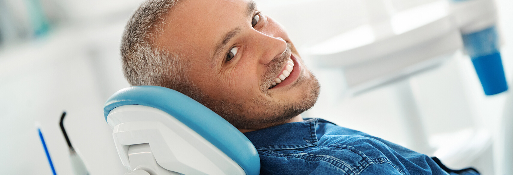 man smiling sitting in a dentist chair