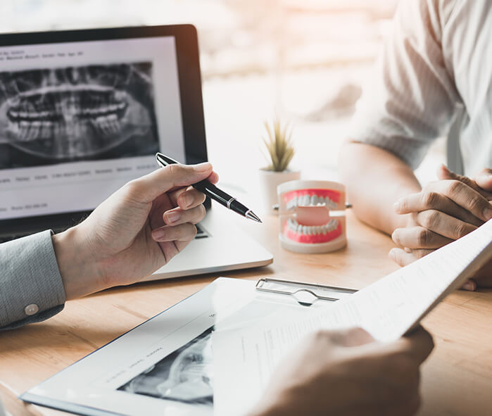 two people discussing dental-related paperwork