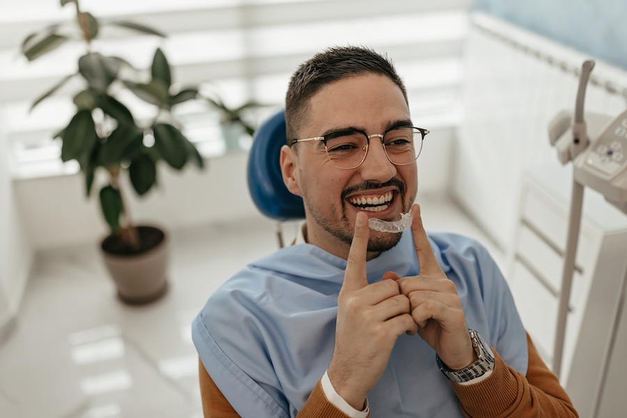 man holding invisalign aligners thinking about caring for invisalign aligners from Walnut Ranch Dental Spa